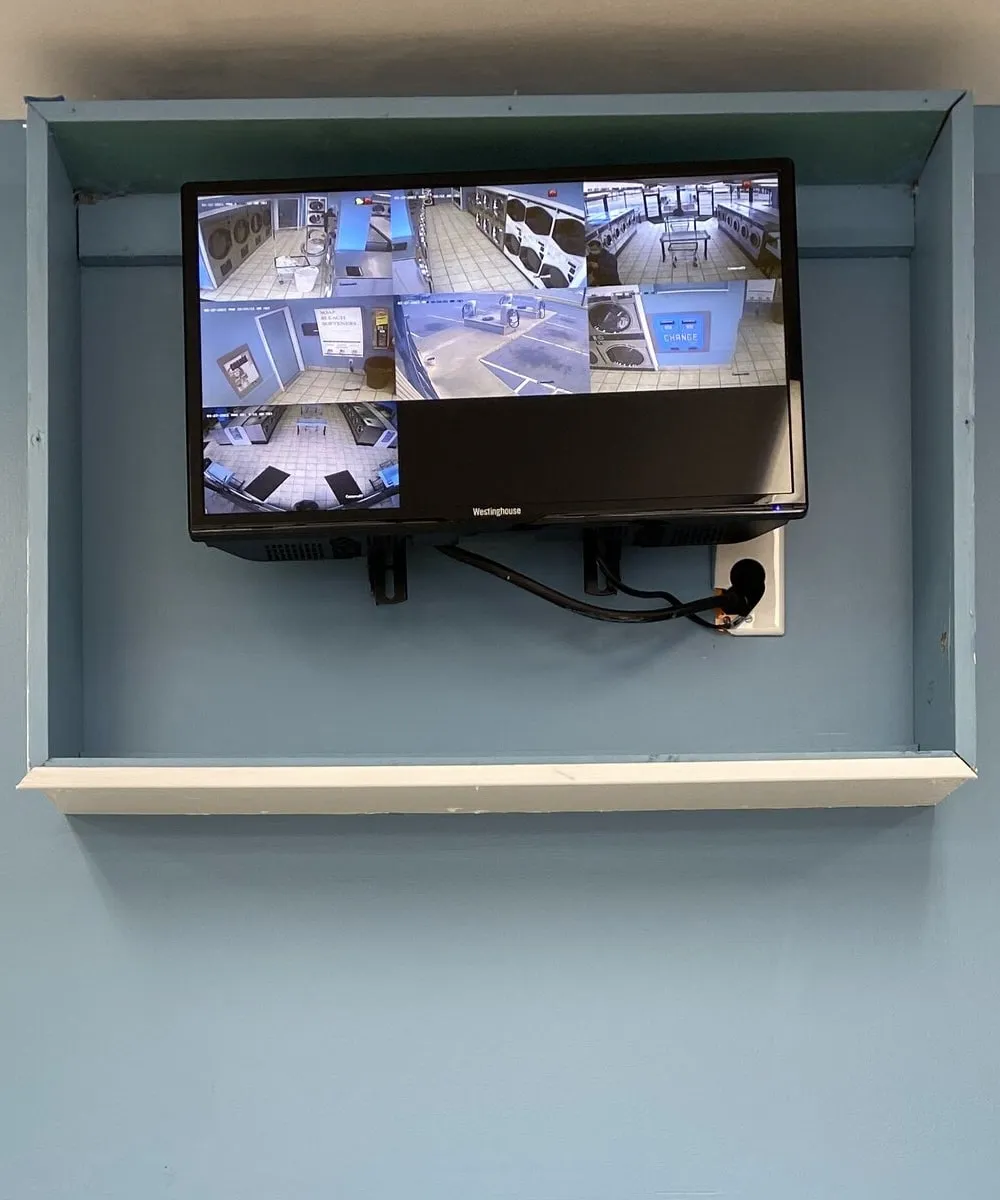 A wall-mounted security monitor showing live views from the store’s cameras.