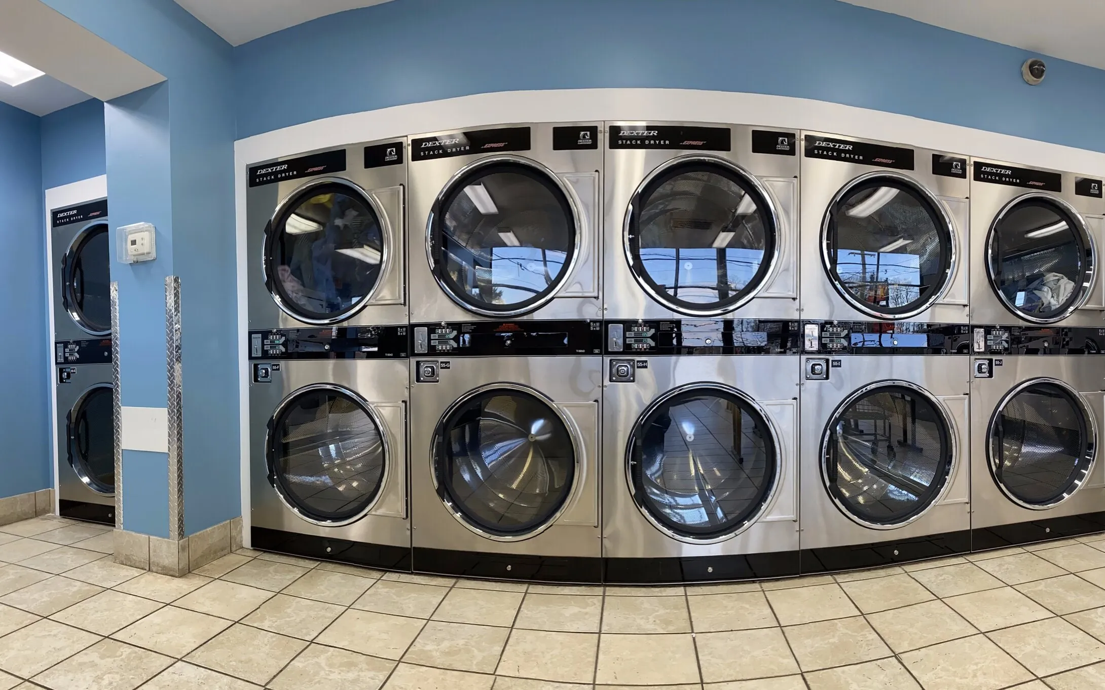 A bank of stacked dryers, two doors high, along one wall.