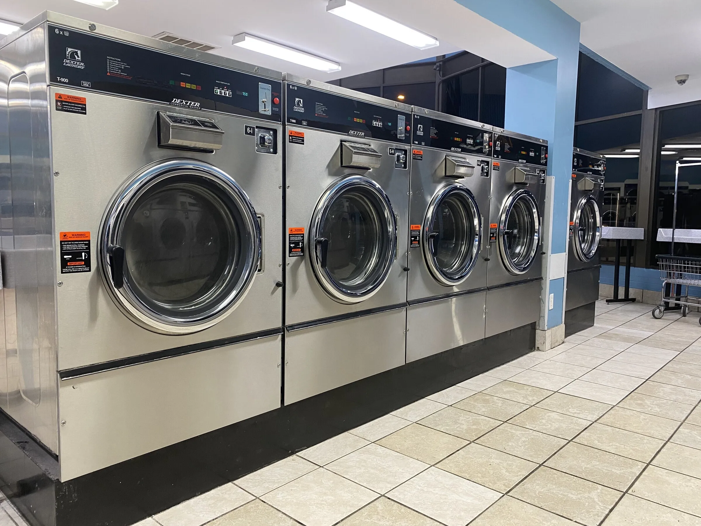 60-pound washers with a laundry cart and folding table behind them.