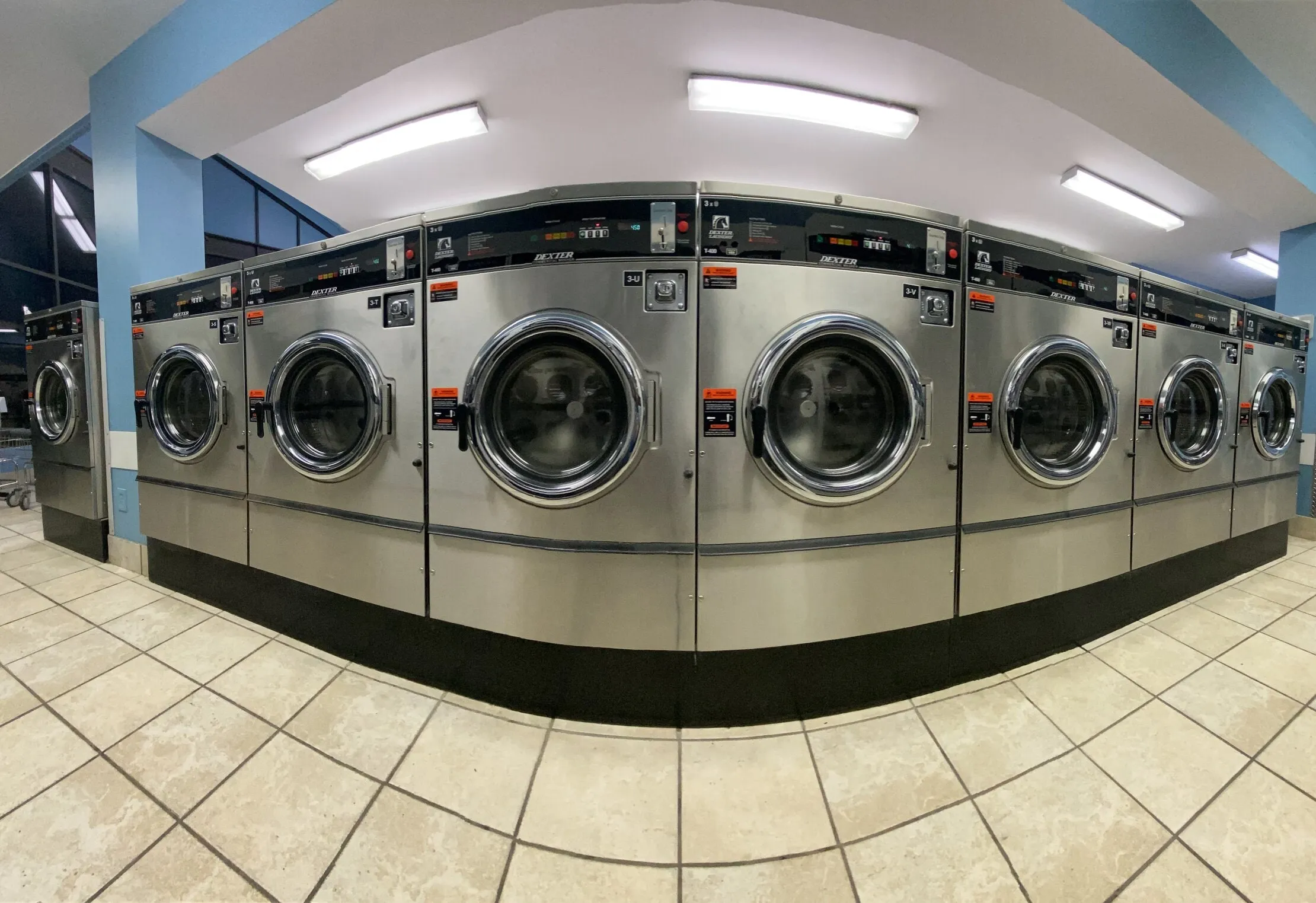 A long row of front-load washers on a clean floor.