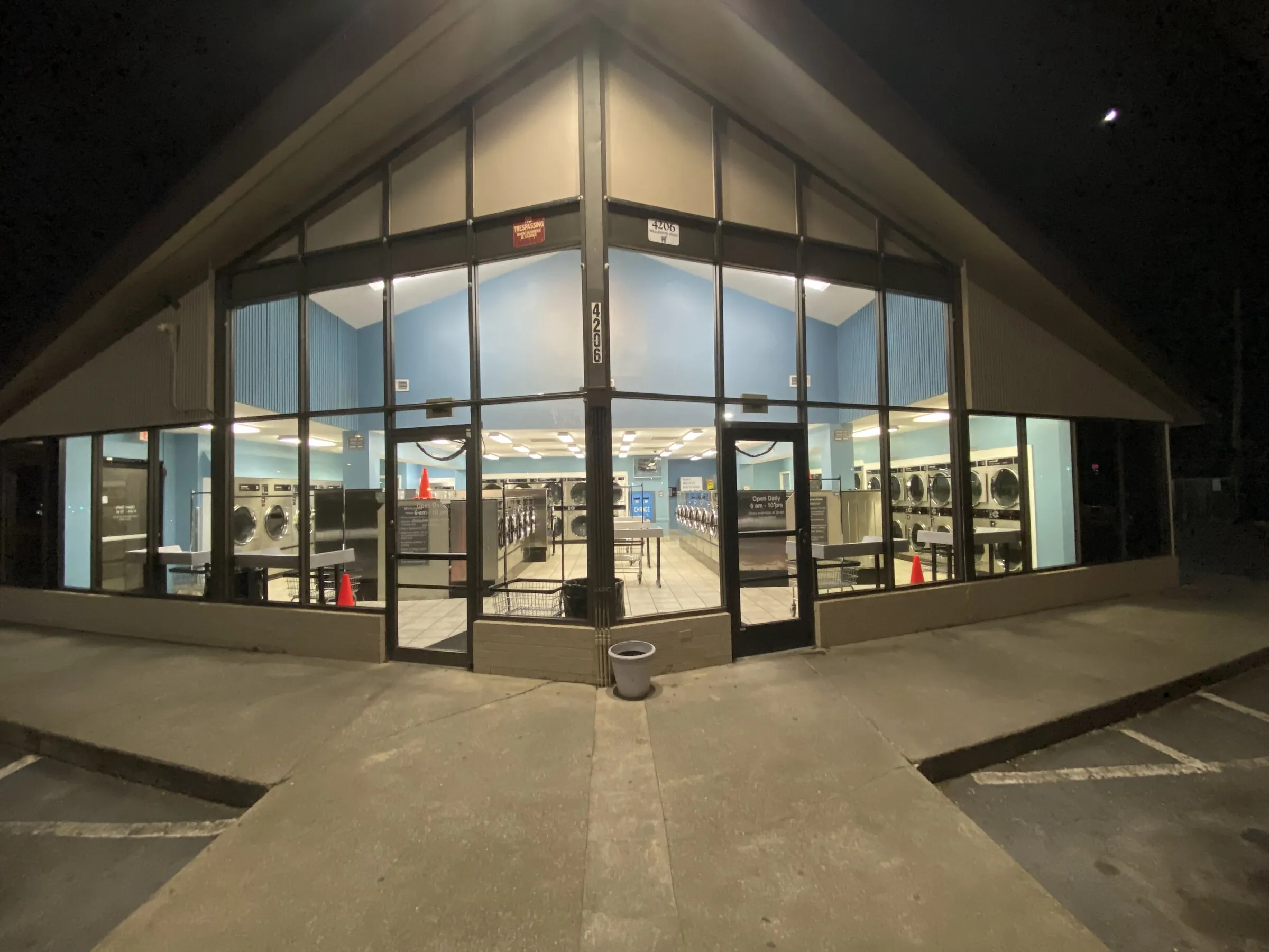 The store entrance at night, lit from inside, with parking spaces right at the door.